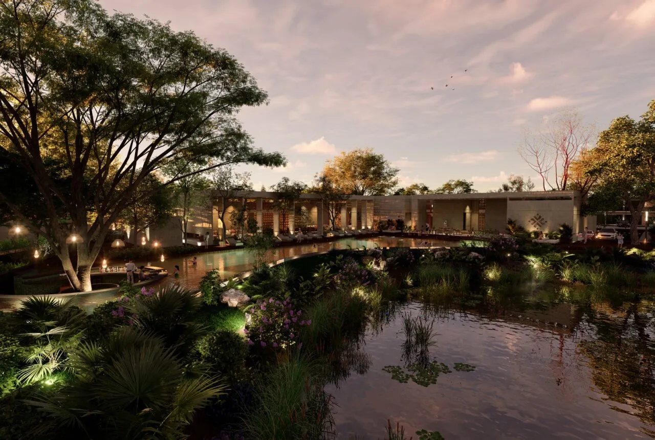 La casa club al atardecer, con el lago iluminado